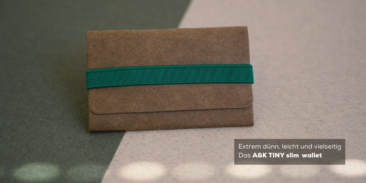 Das A&K TINY Wallet in Braun, akzentuiert mit einem grünen elastischen Band, bietet Kreditkartengröße und ist extrem dünn und leicht.